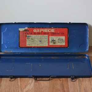 May include: A blue metal toolbox with a red label that reads "62 Piece 1/4 & 3/8 Square Drive Combination" and "Made in Japan".