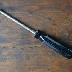 May include: A black and silver screwdriver with a metal handle and a black plastic grip.