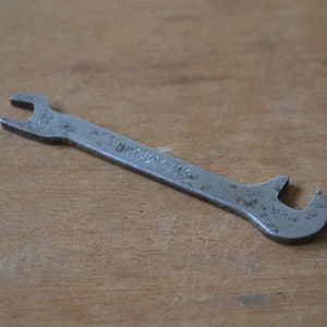 Op de afbeelding: Een zilveren moersleutel met een uniek ontwerp en de tekst "MADE IN ENGLAND" op de handgreep.