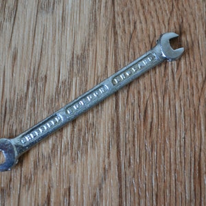 May include: A silver wrench with the text "Griffin  Cutter England" on the handle.