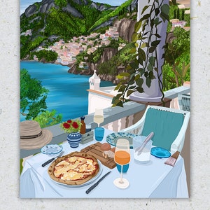Puede incluir: Una mesa puesta con un mantel blanco, una pizza, un vaso de zumo de naranja, una copa de vino blanco, un sombrero de paja, un jarr&oacute;n con flores rojas y una vista de Positano, Italia. El texto "positano, 40.6281&deg; N, 14.4850&deg; E" est&aacute; escrito debajo de la imagen.