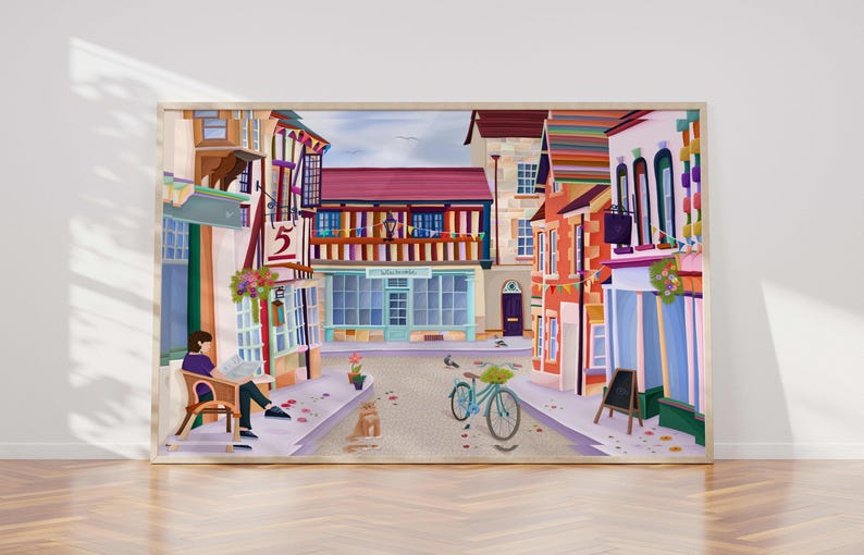 May include: A framed art print depicting a quaint European street scene. The artwork features colorful buildings, a bicycle, and a person reading a newspaper. The color palette includes shades of red, blue, and yellow, creating a vibrant and inviting atmosphere.