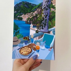 Puede incluir: Una pintura que representa una mesa puesta con una pizza, un vaso de zumo de naranja y una vista de una ciudad costera en el fondo. La mesa est&aacute; puesta con un mantel azul, platos blancos y cubiertos. La pizza est&aacute; cubierta de queso y tiene una corteza ligeramente quemada. El vaso de zumo de naranja est&aacute; medio lleno y tiene una pajita. La vista de la ciudad costera en el fondo muestra una serie de edificios en una ladera. El cielo es azul y hay nubes en el cielo.