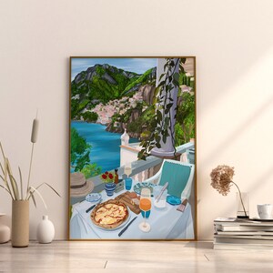 Puede incluir: Una ilustraci&oacute;n enmarcada de una mesa puesta con una pizza, un vaso de zumo de naranja y un sombrero en un balc&oacute;n con vistas a una ciudad costera con colinas verdes en el fondo.