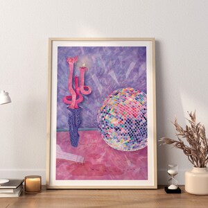 Puede incluir: Una ilustraci&oacute;n enmarcada de un candelero rosa con tres velas, una bola de discoteca y un suelo rosa. El fondo es una acuarela de color p&uacute;rpura.