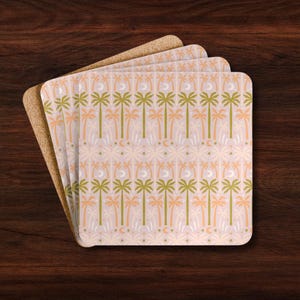 May include: A stack of square coasters with rounded corners featuring a repeating pattern of palm trees, crescent moons, and small dots. The design uses a color palette of muted olive green, soft peach, and cream on a light pink background.