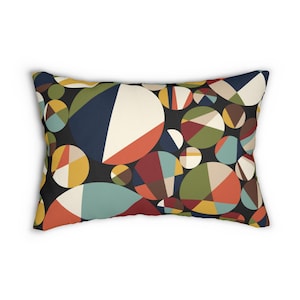 May include: Rectangular decorative pillow with a geometric pattern of overlapping circles in various colors. The circles feature segments of cream, navy, red, orange, green, and yellow on a black background. The pillow is a home decor item.