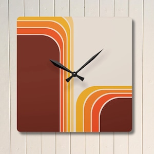 Puede incluir: Reloj de pared cuadrado con un diseño retro. La esfera del reloj presenta un fondo marrón y crema con rayas curvas naranjas y amarillas. Las manecillas negras indican la hora.