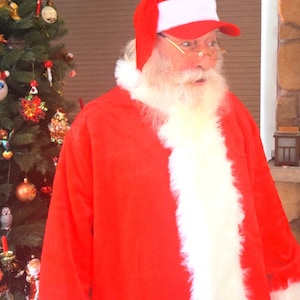May include: A Santa Claus wearing a red suit with white trim, a red hat with a white band, and gold-rimmed glasses. He has a white beard and mustache.