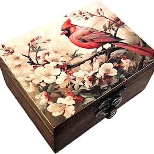 May include: A rectangular wooden box with a dark brown finish and a metal latch. The lid features a printed illustration of a bright red cardinal bird perched on a branch surrounded by clusters of white and pale pink cherry blossom flowers.