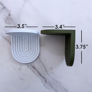 a set of mini wall hanging shelves with a modern ribbed arched design, shown in a variety of colors. the shelves are about 3.5 inches on all sides.