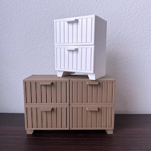May include: Two sets of drawers, one white and one brown. The white drawer set has two drawers and the brown drawer set has four drawers. Both sets have a wood-like texture.