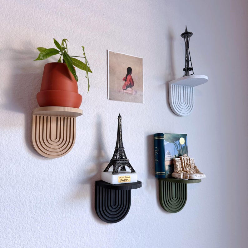 a set of mini wall hanging shelves with a modern ribbed arched design, shown in a variety of colors. The shelves hold small items.