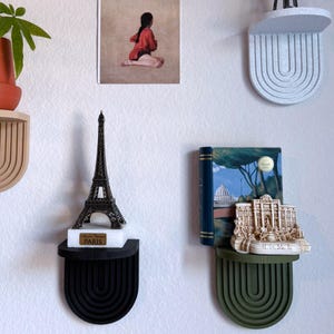 a set of mini wall hanging shelves with a modern ribbed arched design, shown in a variety of colors. The shelves hold small items.