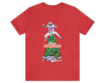 May include: Red t-shirt featuring a football player jumping over a Christmas tree. The tree is decorated with ornaments and presents. The text "Merry Billsmas" is displayed below the tree.