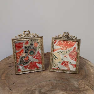 A pair of brass bow picture frames