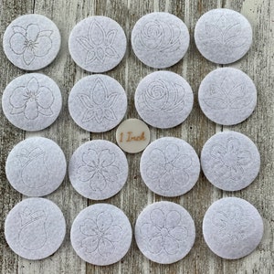 May include: Set of 16 white felt circles with various flower and leaf designs, each measuring 1 inch in diameter. The designs are outlined in a light gray color.