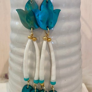 May include: Teal and green shell flower dangle earrings with white shell beads and gold accents.