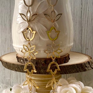 May include: Gold tone dangle earrings with a chain of flower and tulip shapes.