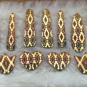 May include: A collection of ten decorative acrylic pieces featuring a reflective gold and dark brown geometric pattern. The set includes six elongated teardrop shapes and four smaller pieces consisting of two heart shapes and two tulip-like floral shapes.