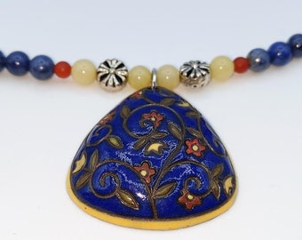 Ceramic blue,red and yellow floral pendent adorned this beautiful beaded necklace.