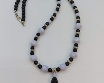 Blue Lace Semi Precious Beads and Black glass beads with silver spacer beads.  It has a Black Glass oblong  pendent.