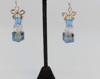 Blue and white Swarovski Crystals topped with a Stirling Silver bow earrings.