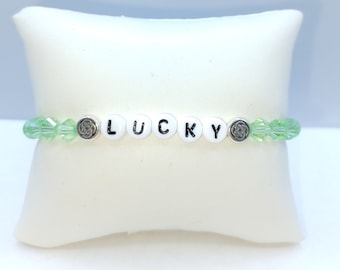 Light green glass beads with Irish knot spacers and the work Lucky.