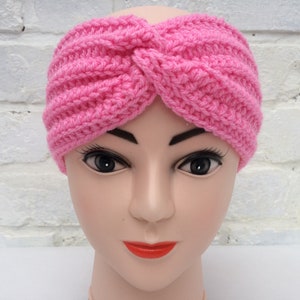 May include: A pink crocheted headband with a twisted knot design.