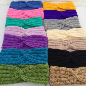 May include: A collection of 14 crocheted headbands in various colors, including pink, purple, teal, green, beige, and black. The headbands are all made with a twisted knot design.
