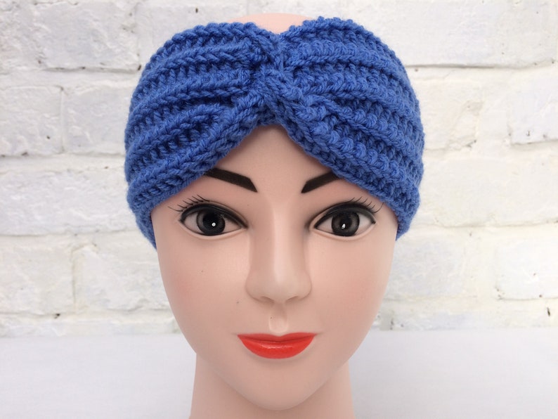 May include: A blue knitted headband with a twisted design. The headband is made of a soft, stretchy yarn and is perfect for keeping your ears warm in the winter.