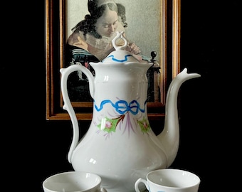 Vieux Bruxelles theepot versierd met bloemmotieven en een blauw lint. Jugendstil