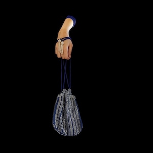 Puede incluir: Una bolsa de cord&oacute;n azul y plata con un asa de cord&oacute;n azul.