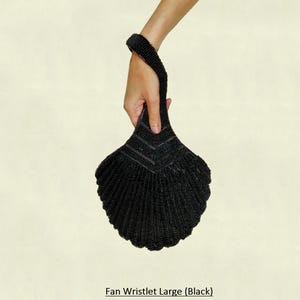 May include: A black beaded fan-shaped wristlet purse with a long handle.