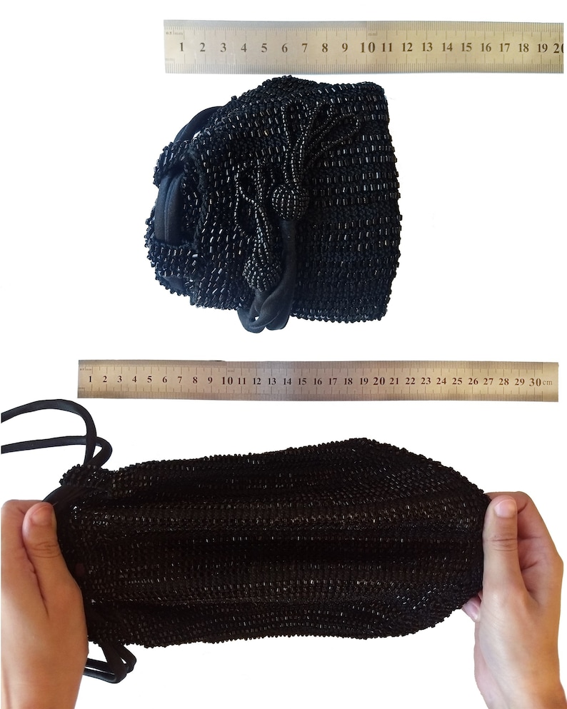 K&ouml;nnte beinhalten: Eine schwarze Perlen-Kordeltasche mit einem langen Quasten. Die Tasche ist etwa 38 cm breit und 25 cm hoch.
