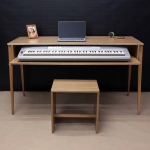 May include: A wooden keyboard stand with a keyboard, laptop, and a small stool. The stand has a light wood finish and is supported by four legs.