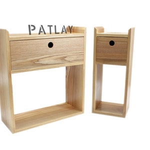 May include: Two wooden wall shelves with a single drawer each. The shelves are made of light wood with a natural finish. The larger shelf has the word "PATLAY" printed on the top.