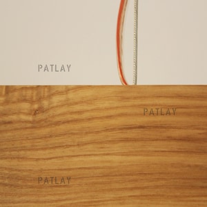 May include: Close-up of a woodgrain surface with the word "PATLAY" printed five times in a light gray color.