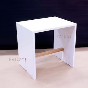 May include: White wooden stool with a single wooden support bar. The stool has a simple, modern design.