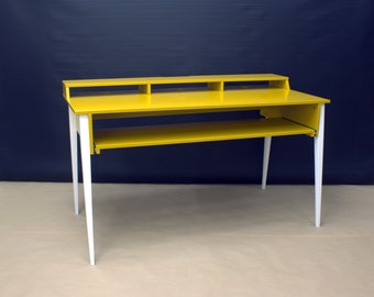 May include: A yellow desk with white legs and a shelf. The desk has a top shelf with two compartments.