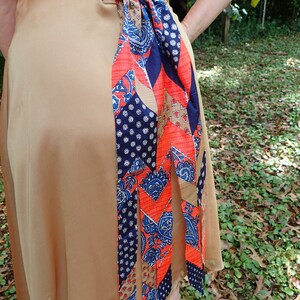 blue and orange multicolored bustle with geometric design and blue trouser cinch clip