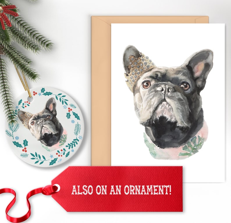 May include: A watercolor illustration of a French bulldog wearing a crown and a floral collar. The image is on a white card with a brown envelope and a white ceramic ornament with a similar design. The text "ALSO ON AN ORNAMENT!" is on a red tag.