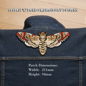 May include: A denim jacket with a large embroidered moth patch. The patch features a detailed design with tan, red, and white accents. The patch is 211mm wide and 94mm high. The text "STITCH 'N BOND EMBROIDERY DESIGNS" is above the patch.