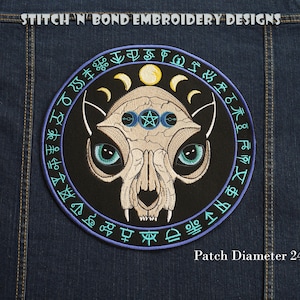 May include: A black and white embroidered patch featuring a skull-like cat face in the centre. The cat has green eyes and a third eye in the centre of its forehead. The cat is surrounded by a circle of blue and purple symbols and the text "Patch Diameter 245mm".
