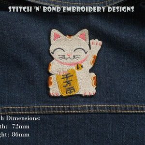 May include: Embroidered iron-on patch of a white Maneki-Neko, or Japanese lucky cat, with a gold coin in its paw and a gold sign that says "千万面". The patch is 7.2 cm wide and 8.6 cm tall.