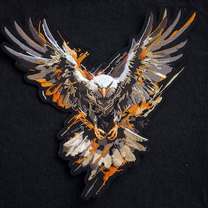 May include: An embroidered patch featuring a black and orange eagle with its wings outstretched. The eagle is in flight and has a fierce expression on its face.