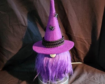 May include: Purple gnome with a purple witch hat with black trim and black spider accents. The gnome is sitting on a round base.