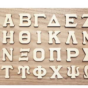 May include: A set of wooden letters in a style called "Style 1" featuring the Greek alphabet. The letters are cut out of wood and are arranged in rows on a wooden surface.