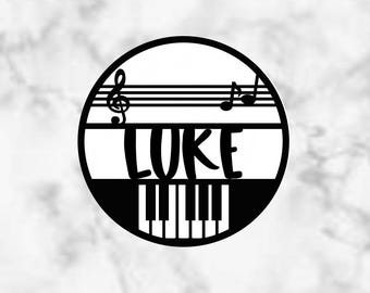 Può includere: Un design circolare in bianco e nero con note musicali, tasti di pianoforte e il nome "LUKE" in un font stilizzato.