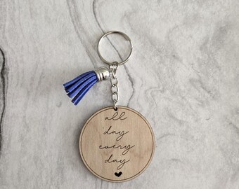 Può includere: Portachiavi in legno con un fiocco blu e il testo "all day every day" con un piccolo cuore in fondo.